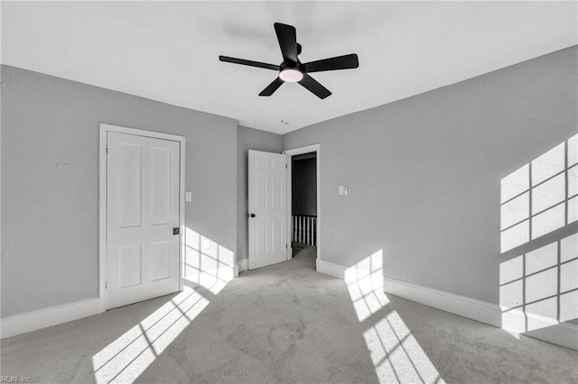 carpeted spare room featuring ceiling fan