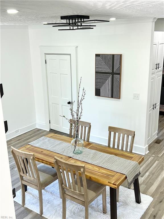 dining area with hardwood / wood-style flooring and a textured ceiling