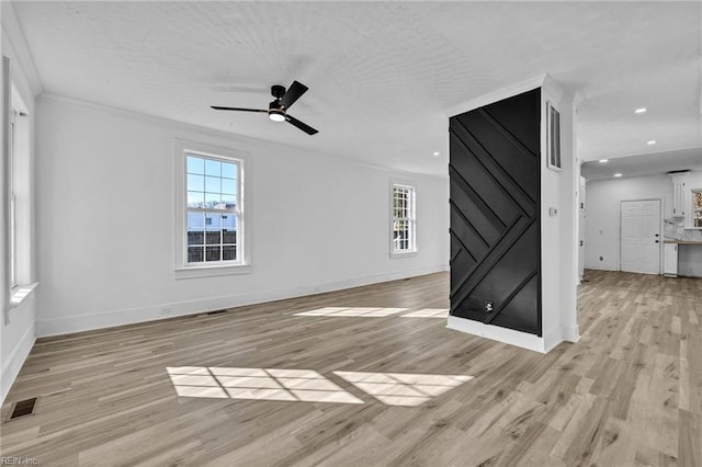 unfurnished living room featuring ceiling fan, crown molding, and light hardwood / wood-style floors