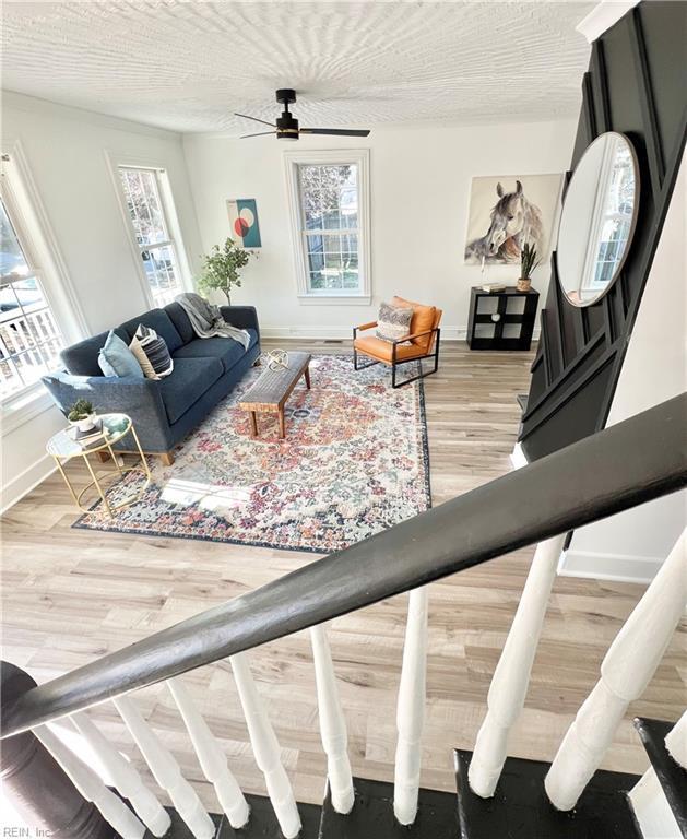 living room featuring ceiling fan and wood-type flooring