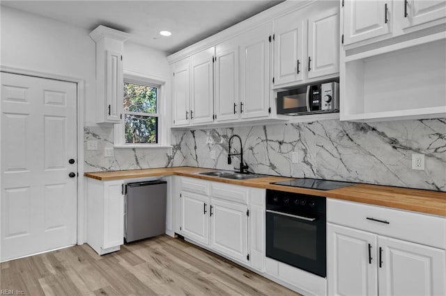 kitchen featuring white cabinetry, black appliances, and wooden counters