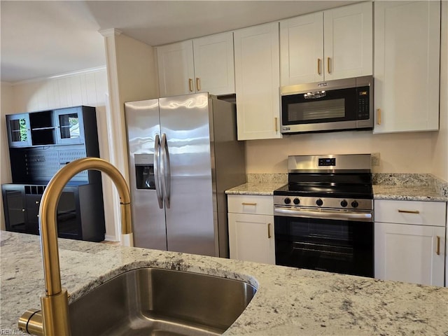 kitchen with white cabinetry, sink, crown molding, and appliances with stainless steel finishes