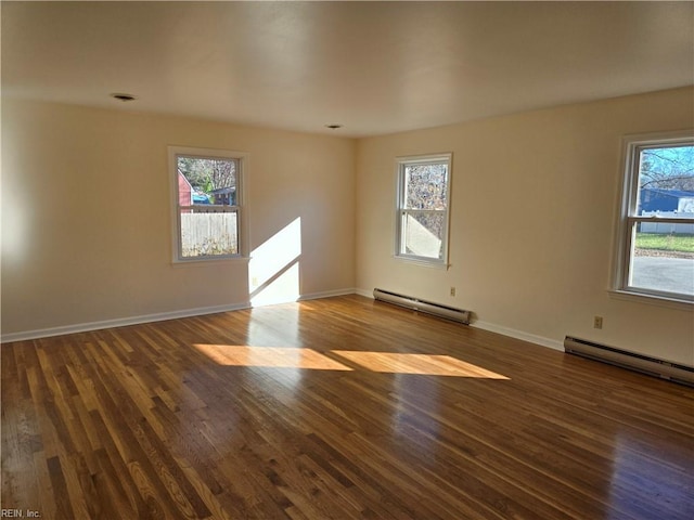 spare room with dark hardwood / wood-style floors and a baseboard radiator