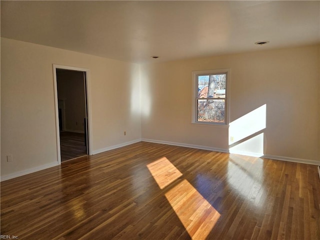 spare room with dark hardwood / wood-style floors