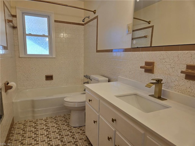 full bathroom with vanity, tiled shower / bath combo, tile walls, and toilet