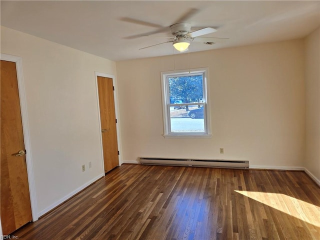 empty room featuring ceiling fan, dark hardwood / wood-style flooring, and a baseboard heating unit