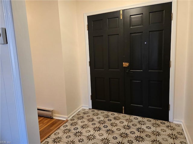 foyer featuring light wood-type flooring and a baseboard heating unit