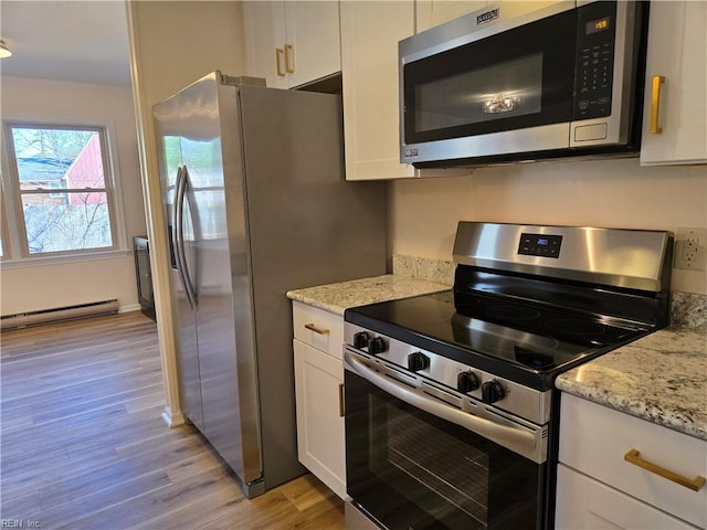 kitchen with white cabinets, light stone countertops, light wood-type flooring, a baseboard radiator, and stainless steel appliances