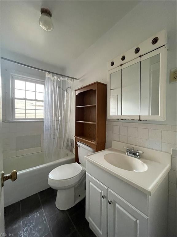 full bathroom with vanity, toilet, tile walls, and shower / tub combo