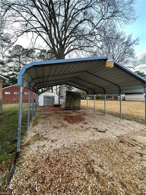 view of car parking with a yard and a carport