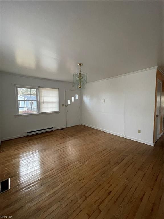 interior space featuring an inviting chandelier, dark hardwood / wood-style floors, and a baseboard heating unit