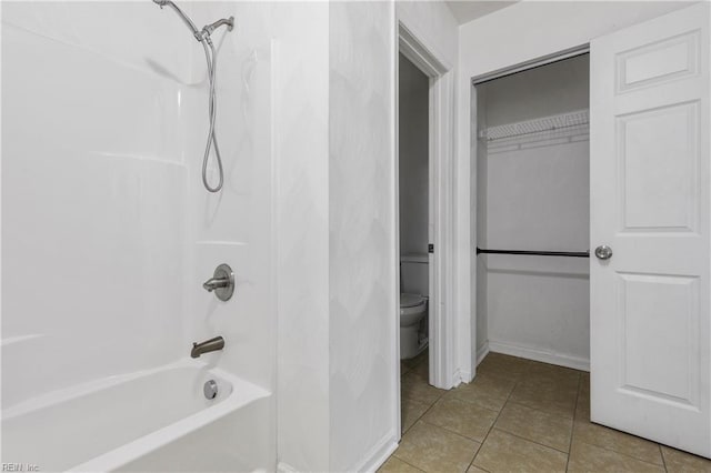 bathroom with tile patterned flooring, shower / bathtub combination, and toilet