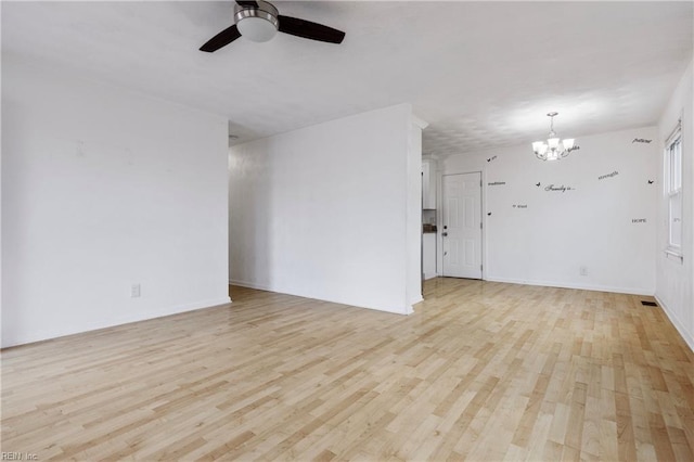 unfurnished living room featuring ceiling fan with notable chandelier and light wood-type flooring