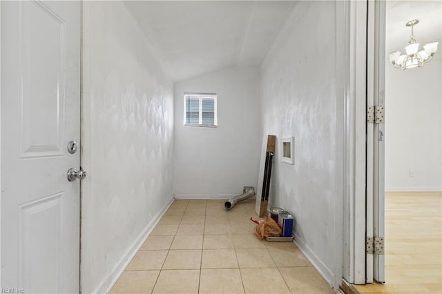 laundry room featuring light tile patterned floors and a chandelier