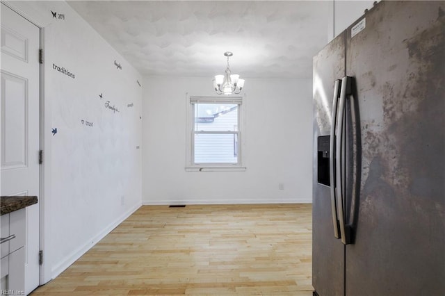 kitchen with a notable chandelier, decorative light fixtures, stainless steel refrigerator with ice dispenser, and light hardwood / wood-style flooring