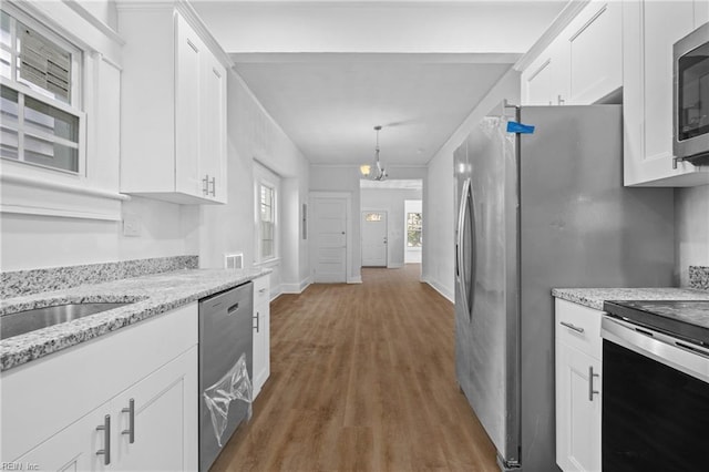 kitchen with white cabinets, dark hardwood / wood-style floors, pendant lighting, and appliances with stainless steel finishes