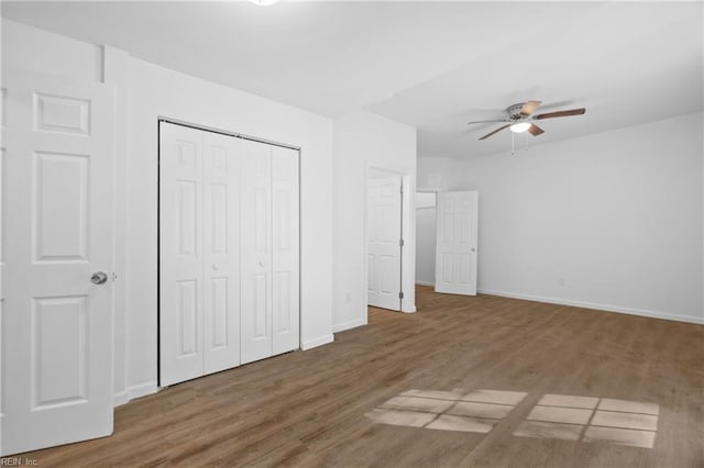 unfurnished bedroom featuring ceiling fan, dark hardwood / wood-style flooring, and a closet