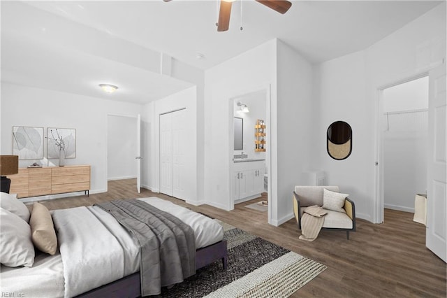 bedroom with ensuite bath, ceiling fan, a closet, and dark wood-type flooring