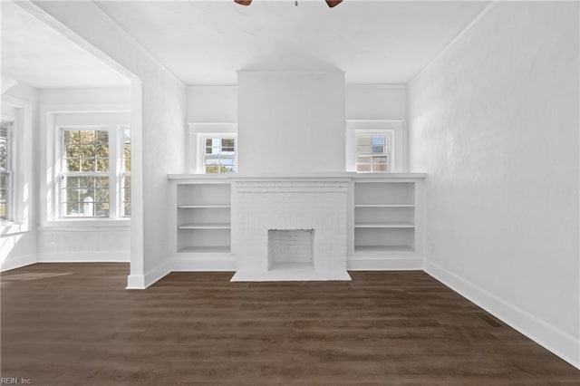 unfurnished living room featuring a fireplace, dark hardwood / wood-style floors, and ornamental molding