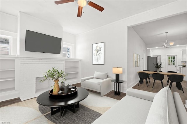 living room featuring wood-type flooring and ceiling fan with notable chandelier