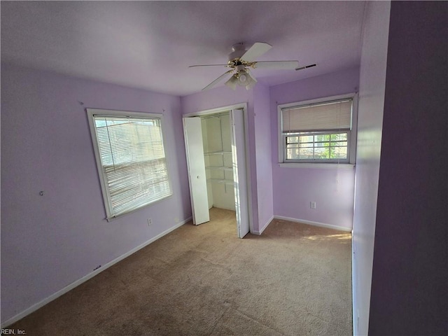 unfurnished bedroom featuring ceiling fan, a closet, and light colored carpet