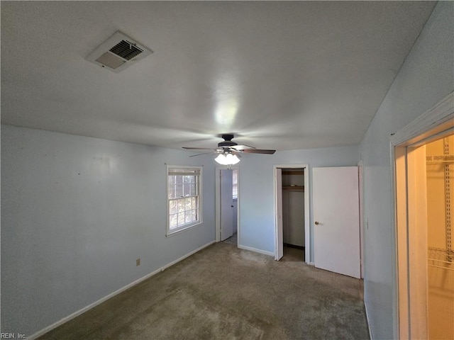 interior space featuring carpet floors, a closet, a spacious closet, and ceiling fan