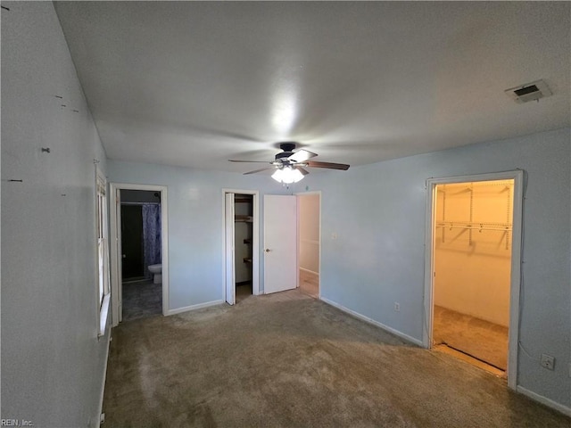 unfurnished bedroom with carpet flooring, connected bathroom, a spacious closet, and ceiling fan