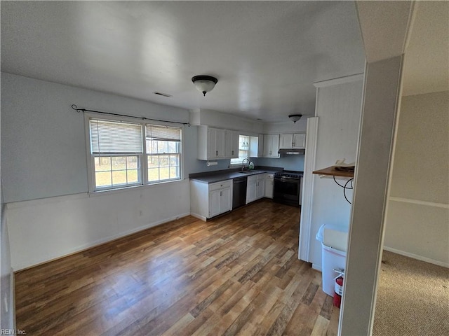 kitchen featuring sink, white cabinets, black appliances, and wood-type flooring