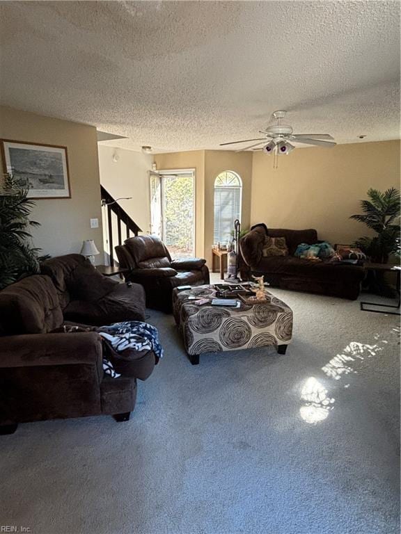 living room featuring carpet, ceiling fan, and a textured ceiling