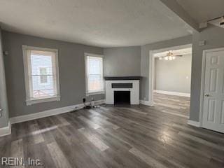 unfurnished living room with dark wood-type flooring and ceiling fan