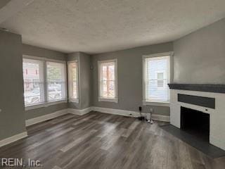 unfurnished living room with dark wood-type flooring and a healthy amount of sunlight