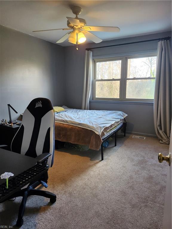 bedroom with carpet, ceiling fan, and multiple windows