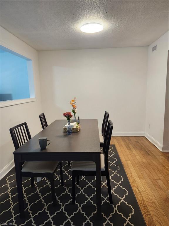 dining room with a textured ceiling and hardwood / wood-style flooring