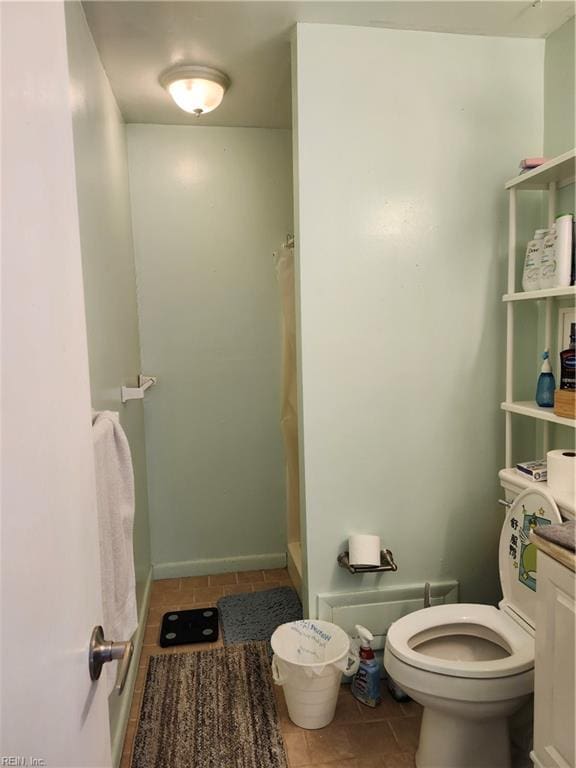 bathroom with a shower, tile patterned flooring, vanity, and toilet