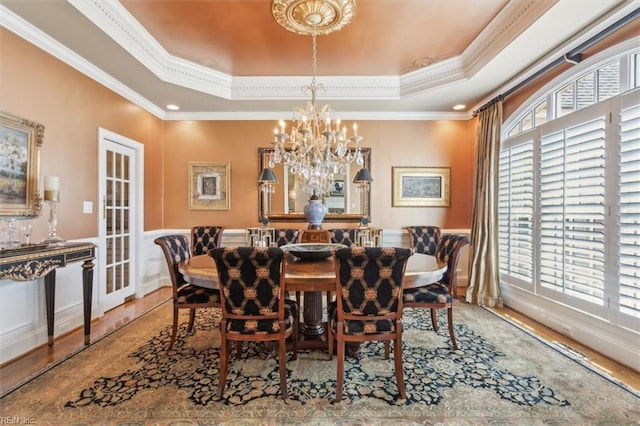 dining space featuring a raised ceiling, crown molding, and a wealth of natural light