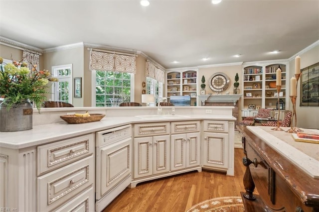 kitchen featuring crown molding, light hardwood / wood-style flooring, white dishwasher, and sink