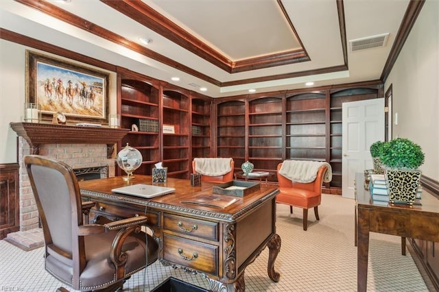 carpeted home office with a brick fireplace, a raised ceiling, and ornamental molding