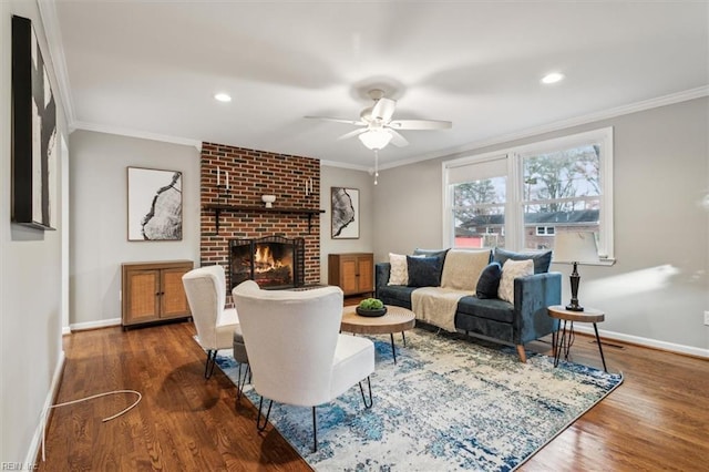 living room featuring dark hardwood / wood-style floors, ceiling fan, ornamental molding, and a brick fireplace