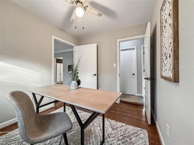 home office with ceiling fan, dark hardwood / wood-style flooring, and crown molding