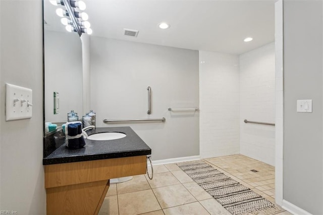 bathroom with tile patterned floors, vanity, and a tile shower