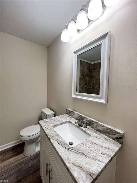 bathroom with hardwood / wood-style floors, vanity, and toilet