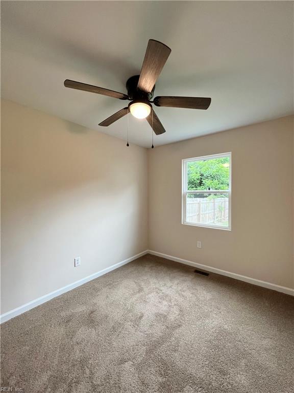 empty room featuring carpet floors and ceiling fan