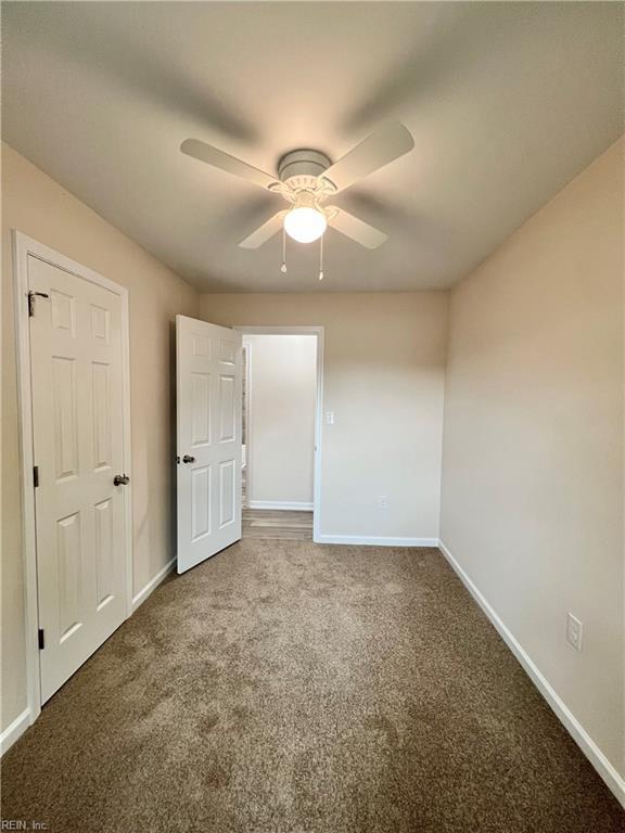 carpeted spare room with ceiling fan