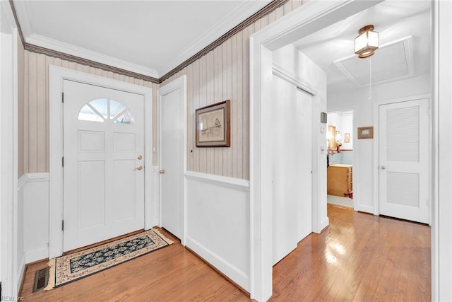 foyer entrance featuring wood-type flooring and ornamental molding