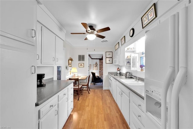 kitchen with ceiling fan, light hardwood / wood-style floors, white cabinetry, and sink