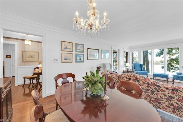 dining room with a chandelier, wood-type flooring, and crown molding