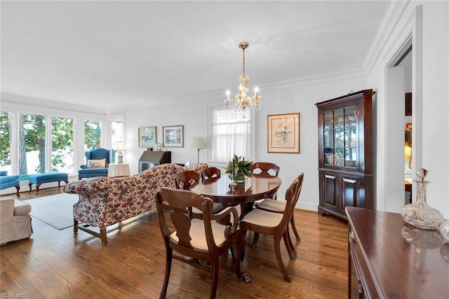 dining space with hardwood / wood-style floors, an inviting chandelier, and ornamental molding