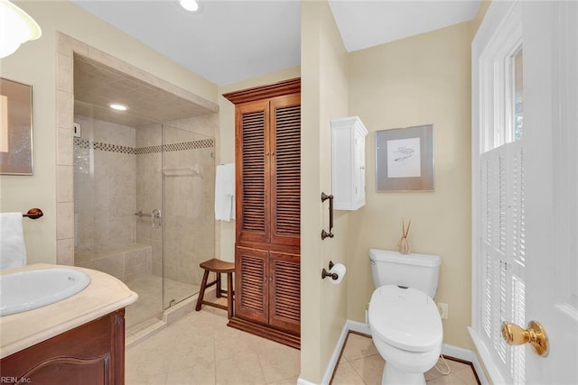 bathroom featuring tile patterned flooring, vanity, toilet, and tiled shower