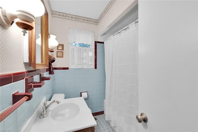 bathroom with a shower with shower curtain, vanity, and tile walls