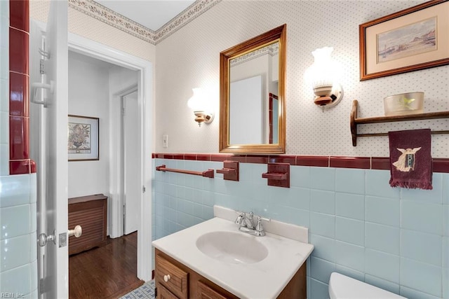 bathroom with vanity, toilet, and tile walls